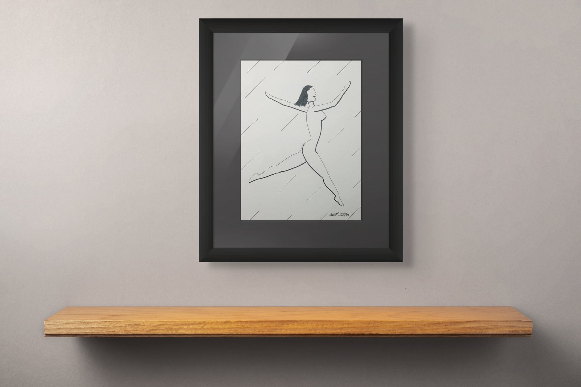 Framed black and white artwork on a gray wall above a wooden shelf