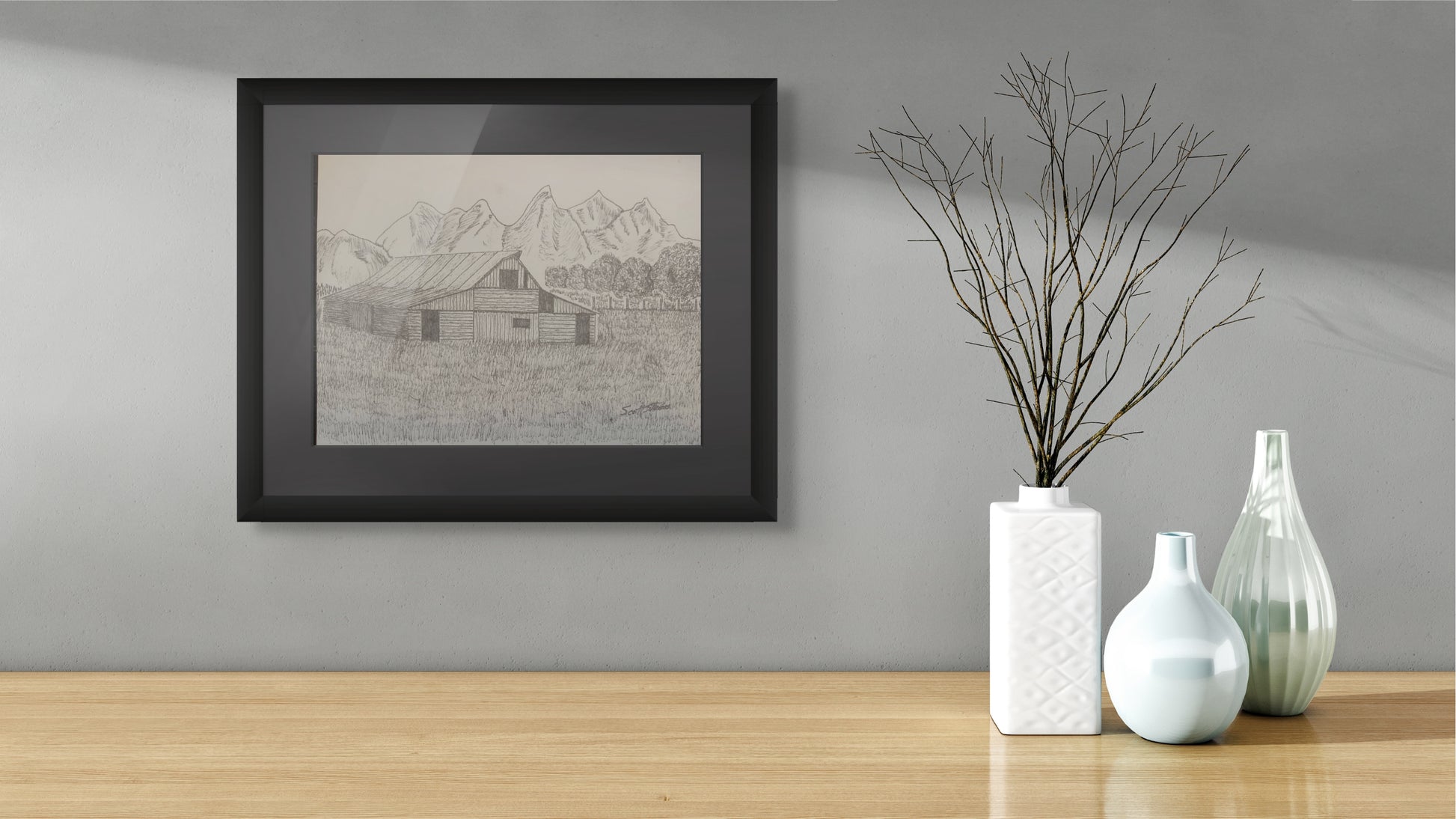 Framed artwork on a wall with decorative vases on a table below.