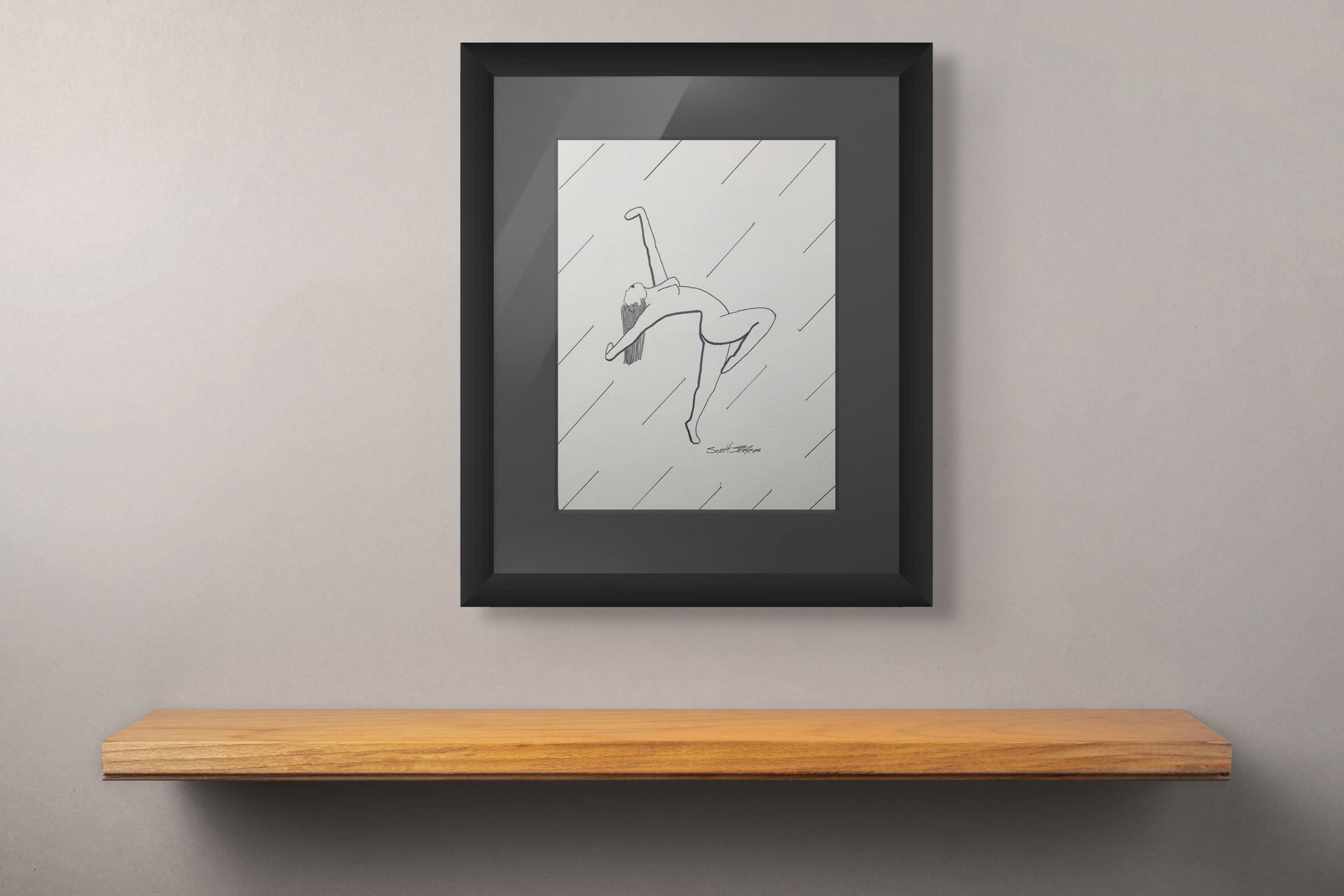 Framed black and white drawing on a wall above a wooden shelf