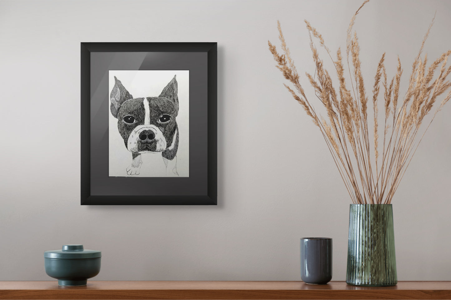Framed artwork of a dog's face on a wall above a shelf with decorative items.