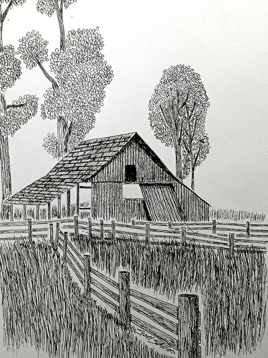 A black and white handcrafted art print of a dilapidated barn in an overgrown field with a fence and trees in the background.