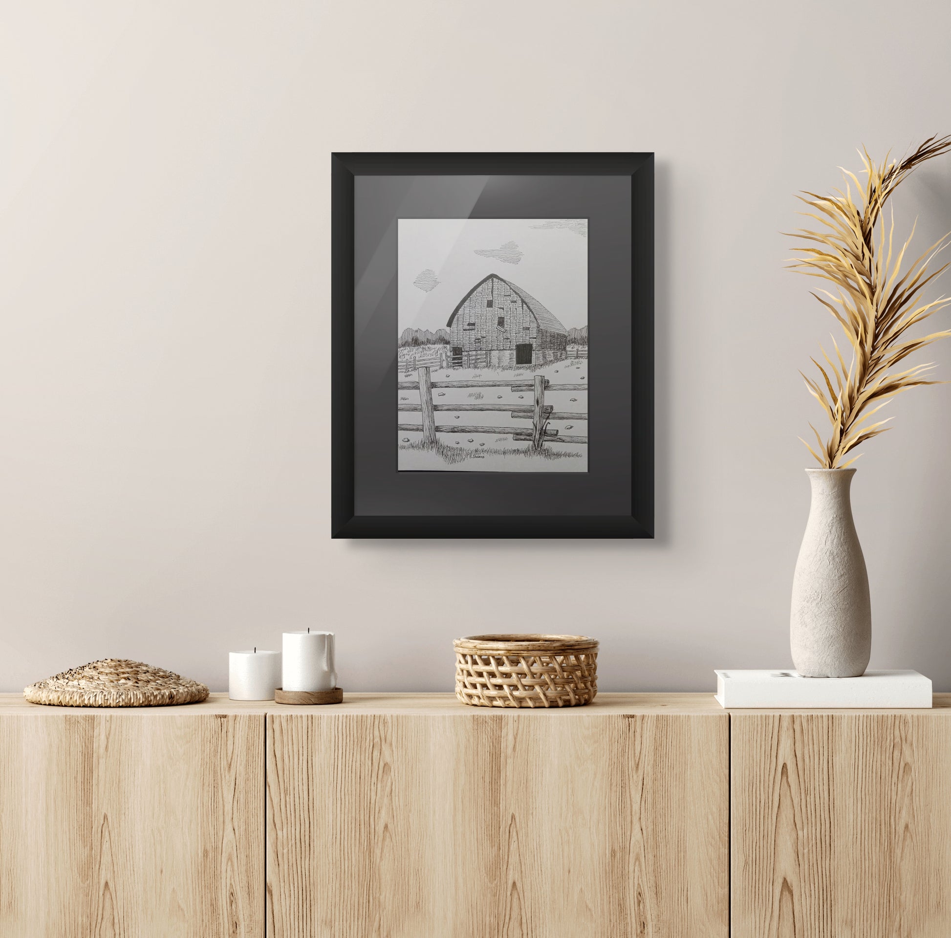 Framed pen and ink drawing of old barn, fence, and stones strewn about
