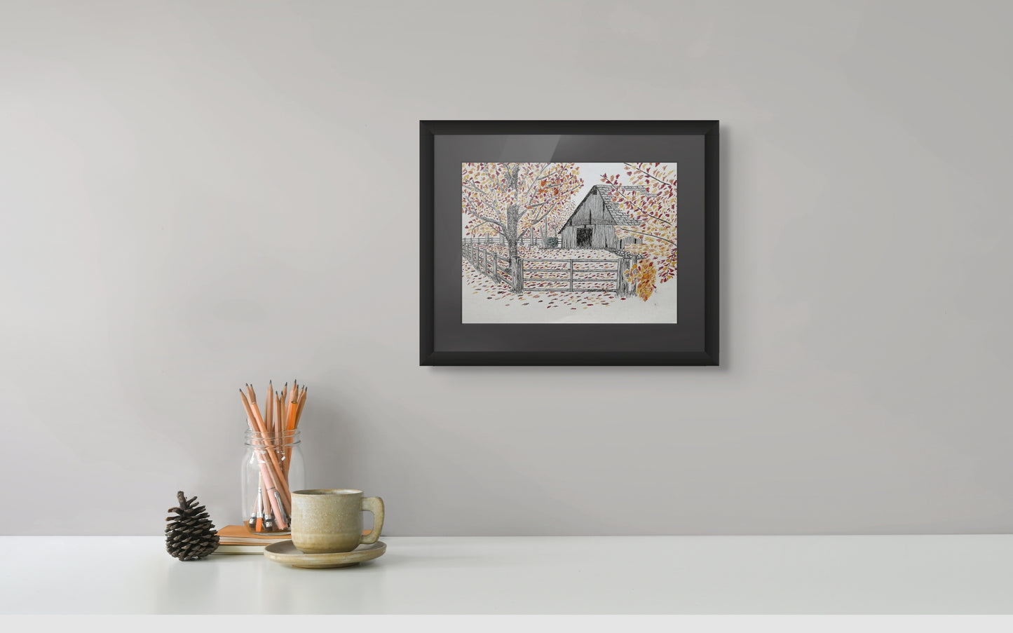 Framed black and white print of an old barn, fence, and trees ablaze in fall colors.