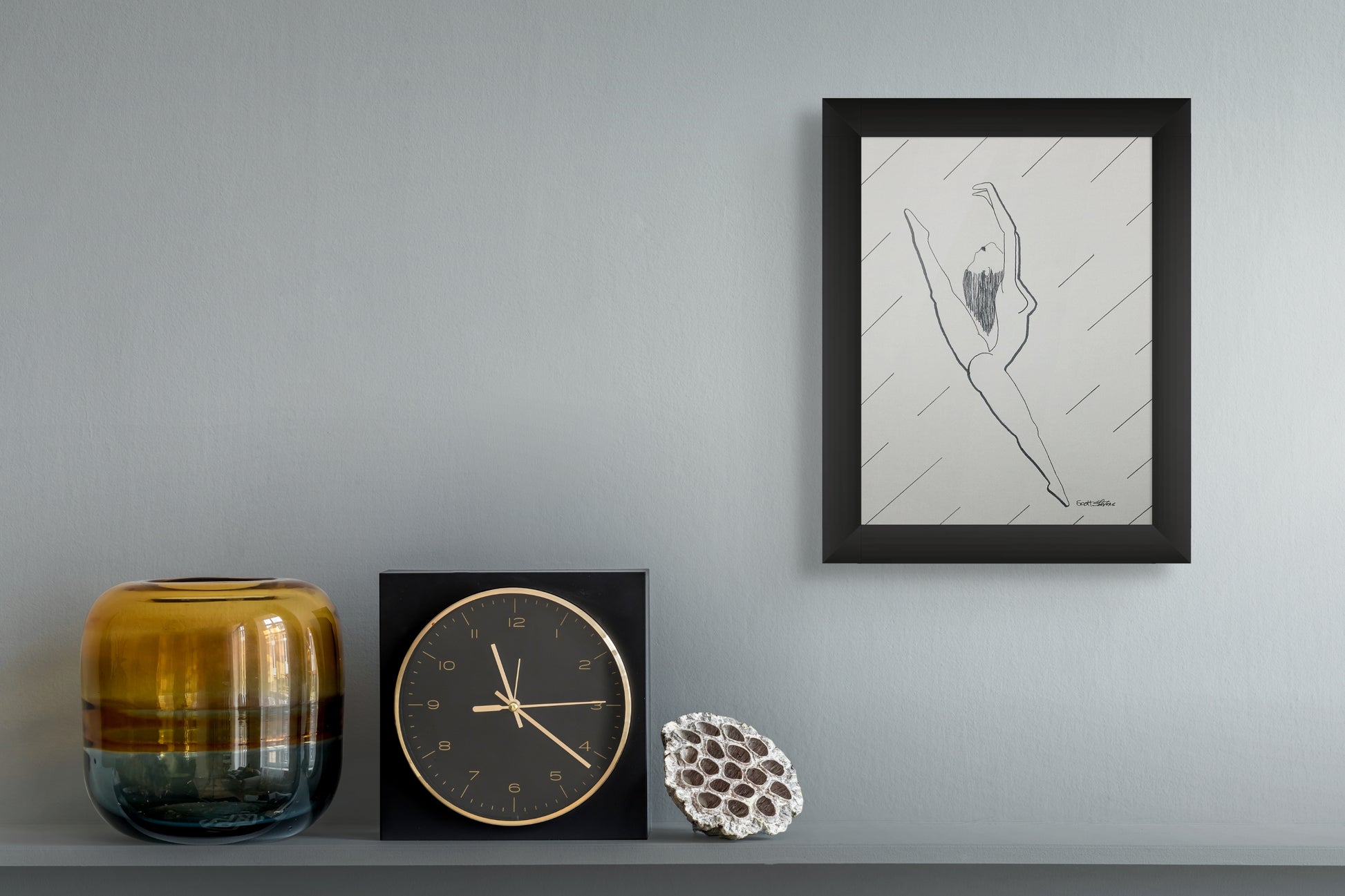 Decorative items including a clock, vase, and framed artwork on a gray surface.