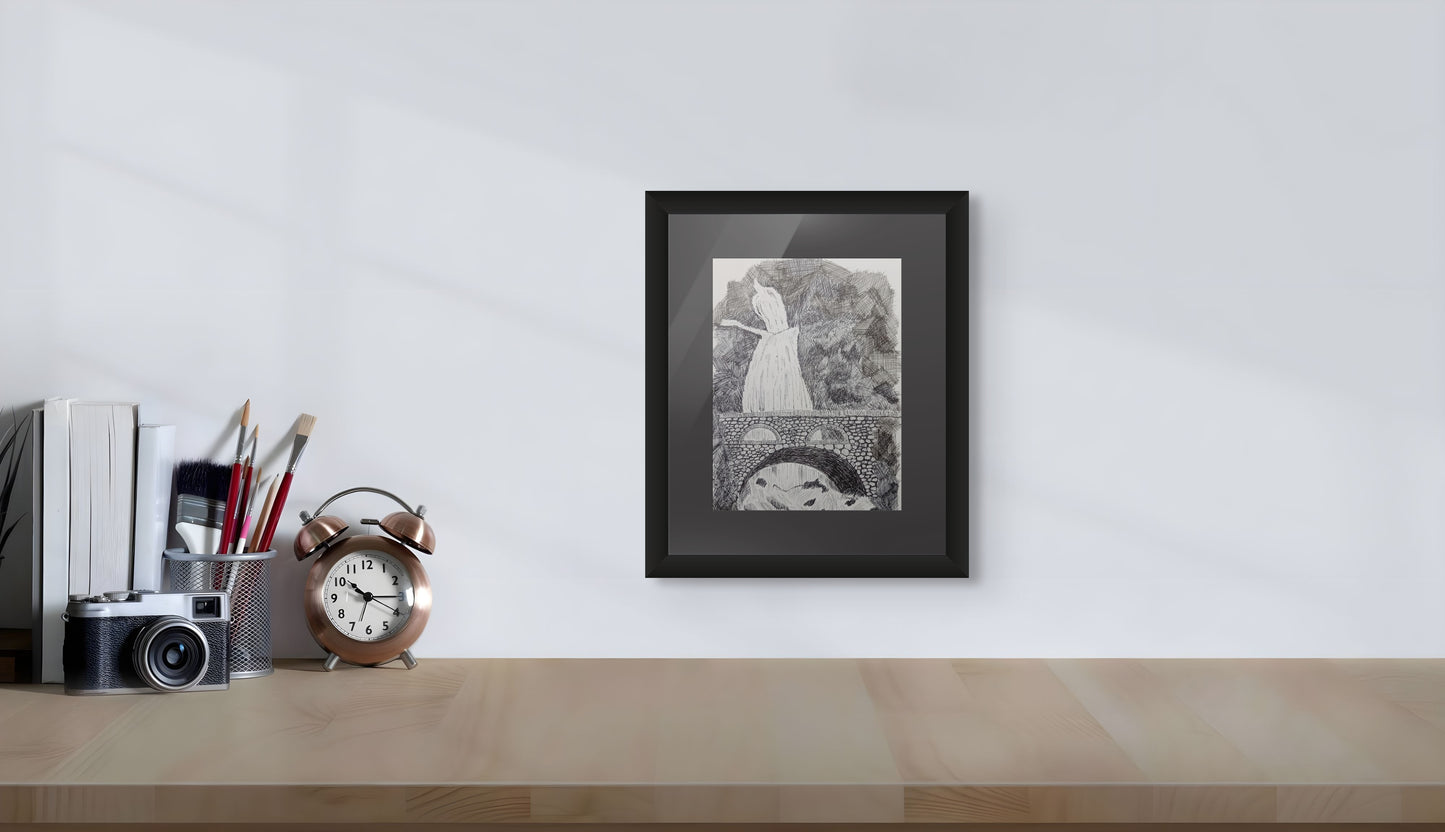 Framed black and white print on a desk with office supplies against a white wall