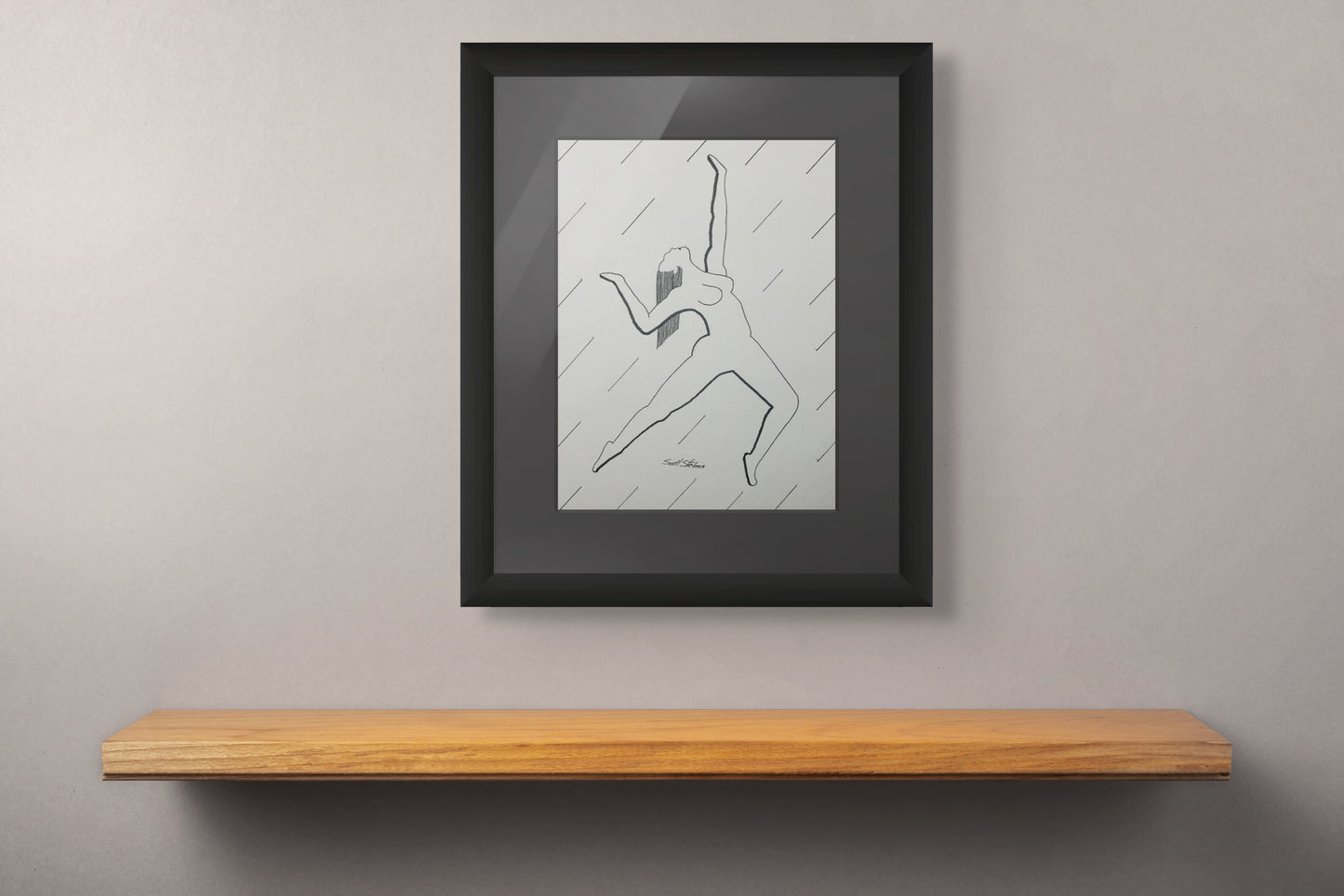 Framed artwork on a wall above a wooden shelf
