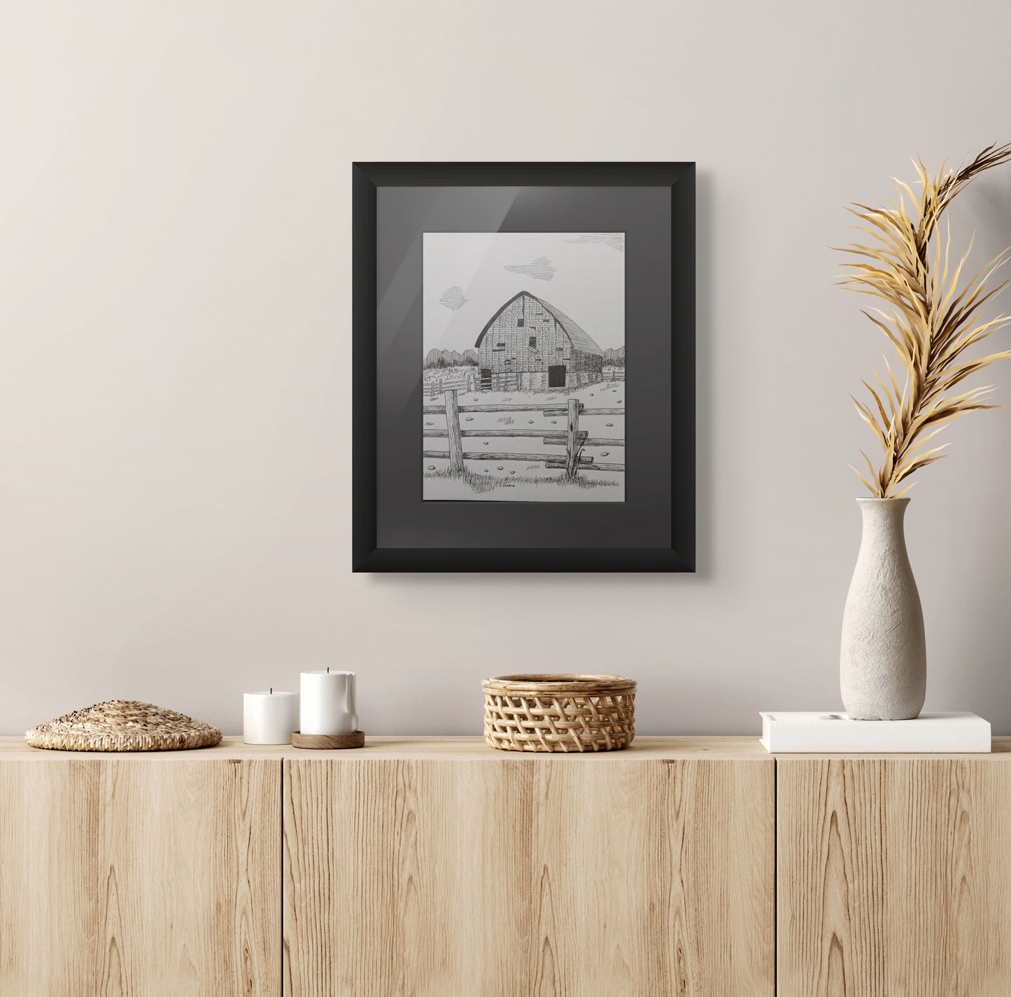 Framed pen and ink drawing of old barn, fence, and stones strewn about
